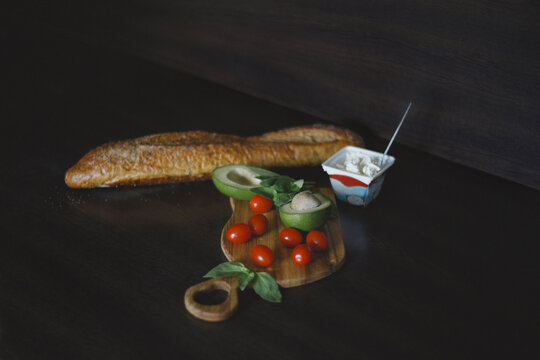 Wide angle of bread, tomato, avocado, curd cheese to prepare toast