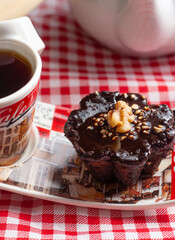 a cup of coffee and a chocolate candie under the wood table