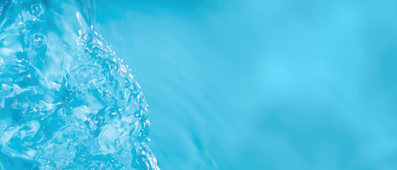 Transparent blue transparent water surface texture with ripples, splashes and bubbles. Abstract water wave banner background in sunlight with copy space