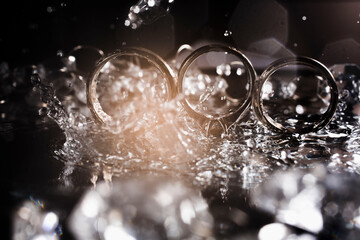 Wedding rings in bright drops of water