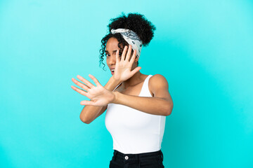 Young latin woman isolated on blue background nervous stretching hands to the front