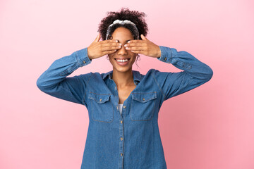 Young latin woman isolated on pink background covering eyes by hands and smiling