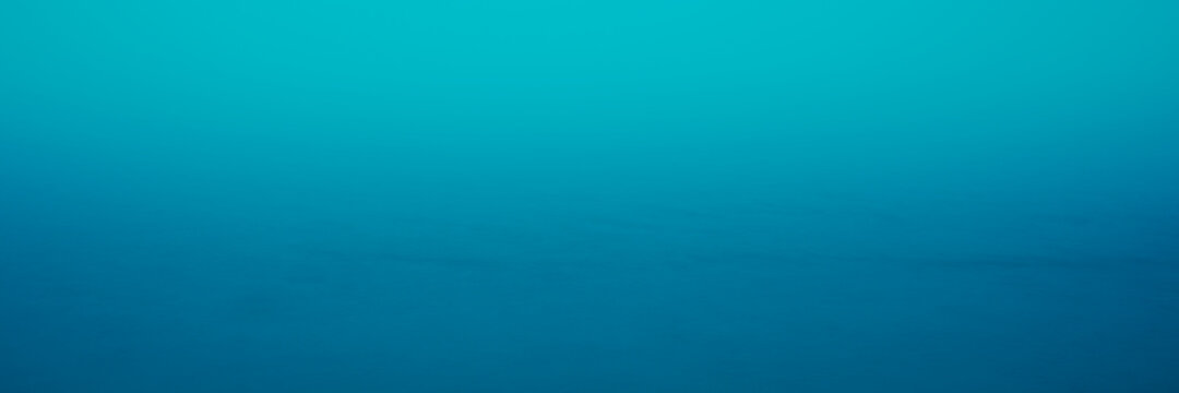 Abstract Seascape Blue Background Photo. Blurred Ocean and Sky on a Foggy Morning. Soft Pastel Space for Text and Design.