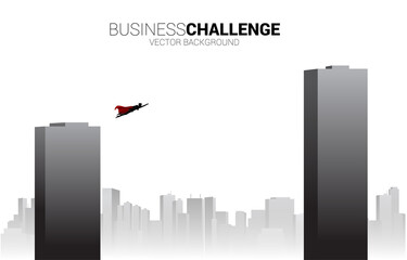 Silhouette of businessman flying across building.Concept for business empower and challenge in career path
