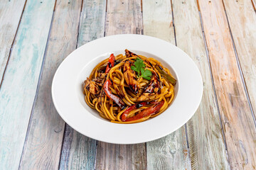 sauteed noodles with a lot of beef tenderloin, lots of tomatoes and red peppers, red onion and chopped chives all cooked with a Peruvian recipe with soy sauce