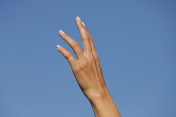 hands on sky background. Sensual woman hand. Cream. Spa. Beauty