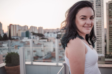 Fototapeta na wymiar portrait of white black haired brazilian woman with building at background