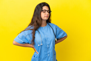 Young surgeon doctor woman isolated on yellow background suffering from backache for having made an effort
