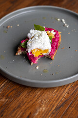 Balinese tasty breakfast with coffee. Toast with hummus and poached egg or scrambled eggs. Hummus from beet.