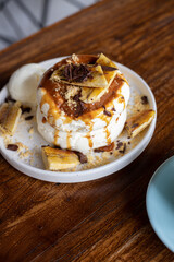 delicious sweet breakfast, pancakes with banana and strawberries, cream and chocolate, a cup of coffee