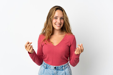 Young blonde woman isolated on blue background making money gesture
