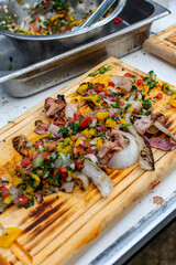 aros de cebolla con tocino a la parrilla  y salsa de mango picado 
montados en tabla de madera 

