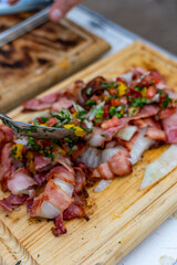 aros de cebolla con tocino a la parrilla  y salsa de mango picado 
montados en tabla de madera 

