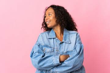 Fototapeta premium Teenager cuban girl isolated on pink background looking to the side