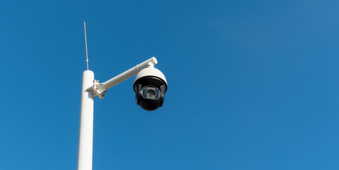 CCTV security cameras on a large post, taken on a sunny bright day with blue sky
