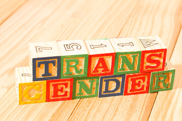 Spectacular wooden cubes with the word TRANSGENDER on a wooden surface.