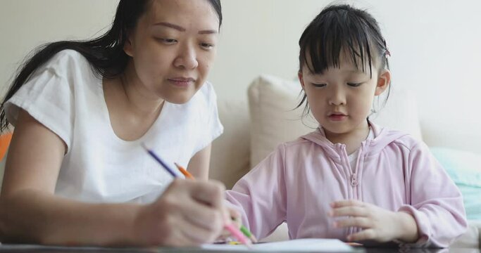 4K Video slow motion Asian mom teach her little daughter draw picture with color pencil. Concept of learning from home and family activity.