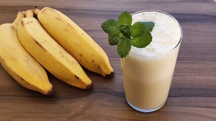 Banana smoothie on the table. Banana shake or banana milkshake is a creamy and nutritious drink. Breakfast and healthy diet.