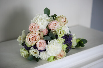 wedding bouquet of the bride in light colors with pink roses, white eustoma with the addition of eucalyptus