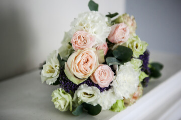 wedding bouquet of the bride in light colors with pink roses, white eustoma with the addition of eucalyptus