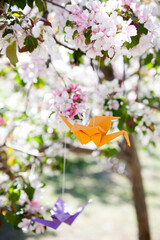 Obraz na płótnie Canvas origami paper crane on a flowering tree