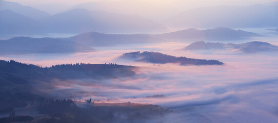 Fototapeta premium mountain valley in blue mist at the early morning