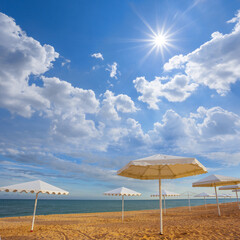 white sun umbrella on sandy sea beach at the sunny day