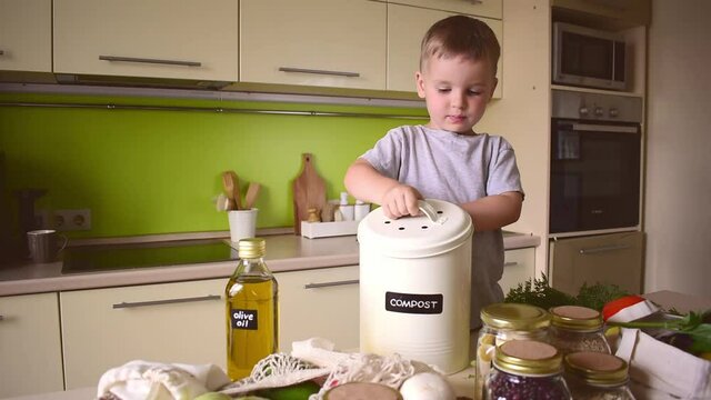 Child boy puts food waste in a compost bin. Waste sorting. Zero waste concept. Plastic free.