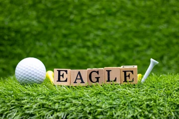  Golf with word Eagle is on green grass. An “eagle” in golf means a score 2-under par on each hole. This golf term is really easy to understand. © thaninee