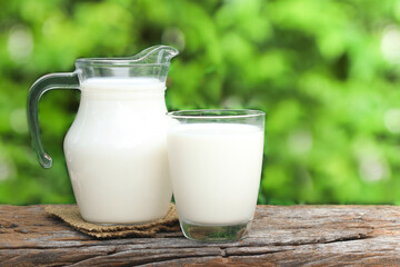 Obraz na płótnie Canvas A jug of milk and glass of milk on a wooden table.