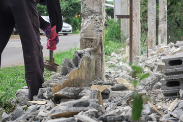 worker builder using hammer and smash tool at construction site. Man using sledge-hammer. Labor are using hammer smash destroy cement wall