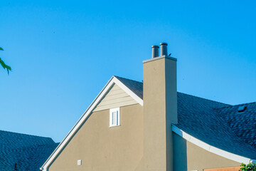Rooftop of a house with attic windows under the blue sky