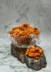 Pork crackling chili paste (Nam prik kag moo) in glass bowl on marble table. Fried chili and Fried...