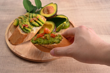 Healthy man holding avocado sandwiches.