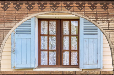 Fenêtre de maison créole derrière store vénitien 