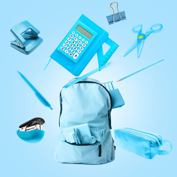 Backpack With Flying School Supplies On Color Background