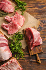 Slices of raw pork meat and parsley on wooden background