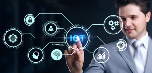 Internet of things - IOT concept. Businessman offer IOT products and solutions. Young businessman  select the abstract chip with text IoT on the virtual display
