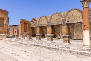 Obraz premium Ruins of an ancient city destroyed by the eruption of the volcano Vesuvius in 79 AD near Naples, Pompeii, Italy. Portico in front of the entrance to the Macellum