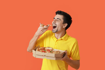 Handsome man eating tasty pizza on color background