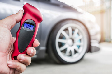 Close up Tire gauge digital and hand a man use for check air pressure of wheel car basic maintenance