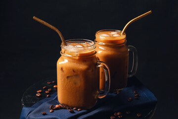 Mason jars of iced coffee on dark background