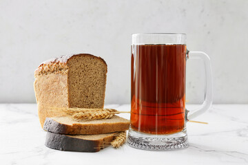 Mug of fresh kvass on light background