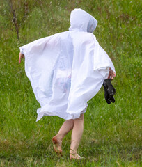 A girl in a white raincoat in the rain