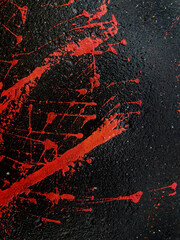 Spilled paint on the asphalt. Grunge texture with splashes and stones. Dark background with bright spots