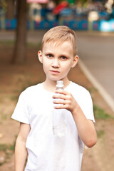 Little boy kid drinking water from a bottle outdoor in a park