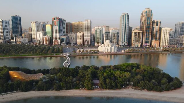 Sharjah aerial view above Al Noor island and mosque and downtown rising above Khalid lake