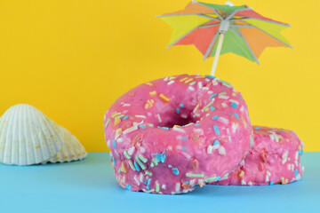 
Front view. Donuts with chocolate and colored noodles. Bottom and base, two colors. Summer decoration.