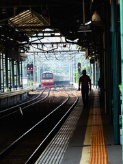 Ttrain in the station, a man walks alone beside the railroad tracks. Jakarta, Indonesia - 16 April...