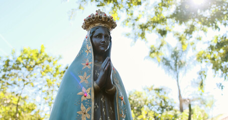 Sculpture of the image of "Nossa Senhora Aparecida" the patroness of Brazil. Image with gimbal on nature background on sunny day.